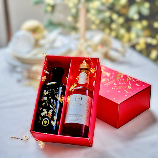 Luxuriöse Geschenkbox mit einer festlich dekorierten Flasche Olivenöl und einer Flasche Balsamico-Essig, elegant in einer roten Box mit goldenen Verzierungen präsentiert. Perfekt als hochwertiges Weihnachtsgeschenk oder für besondere Anlässe.