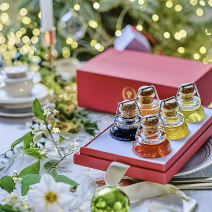 Exklusive Geschenkbox mit einer Auswahl an verschiedenen Gourmet-Ölen in eleganten Glasflaschen mit Korkverschluss. Die farbenfrohe Präsentation enthält verschiedene Sorten Olivenöl und Balsamico, perfekt für besondere Anlässe und festliche Geschenke wie Weihnachten.